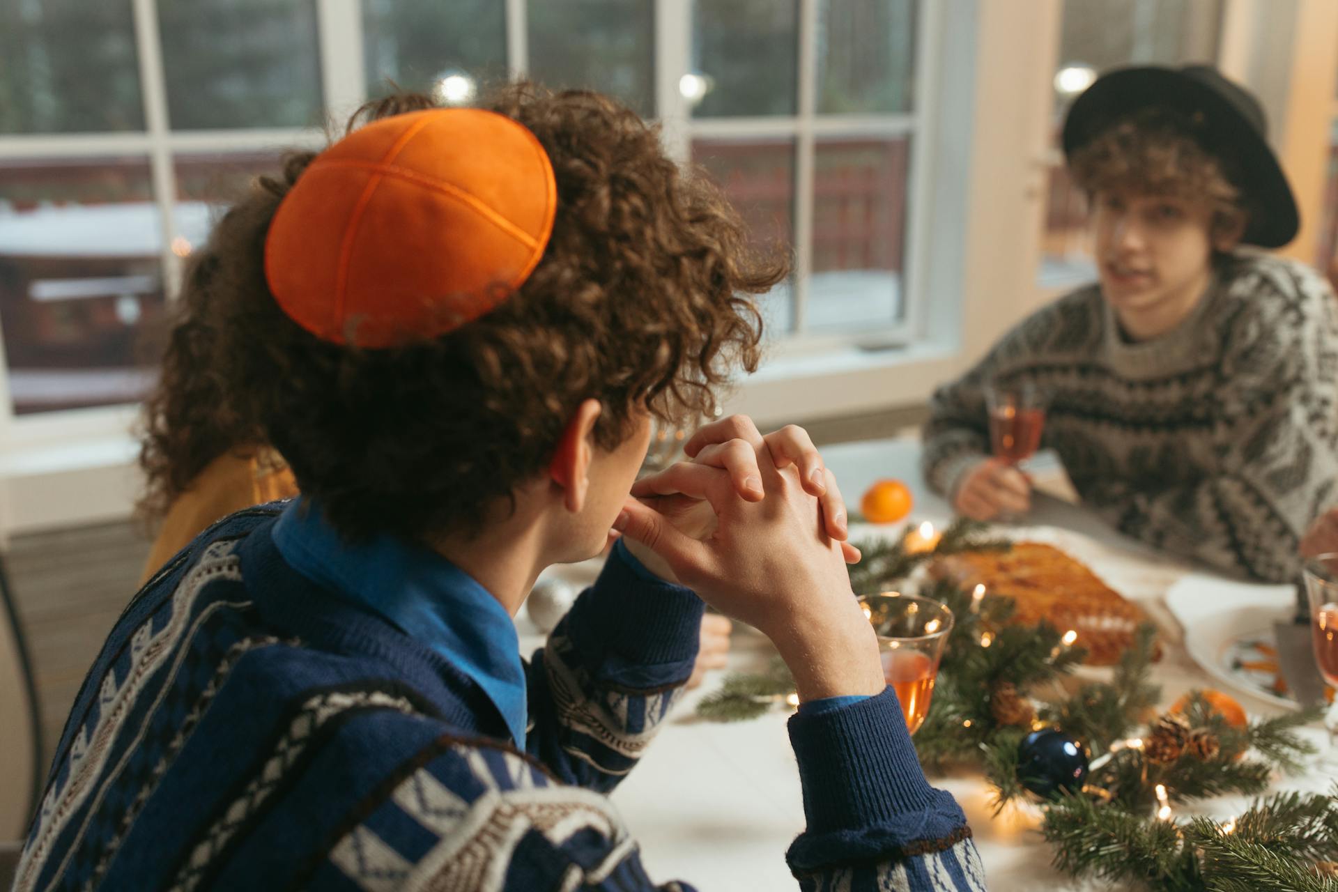 Friends celebrating a holiday with traditional food and decorations, emphasizing Jewish cultural traditions.