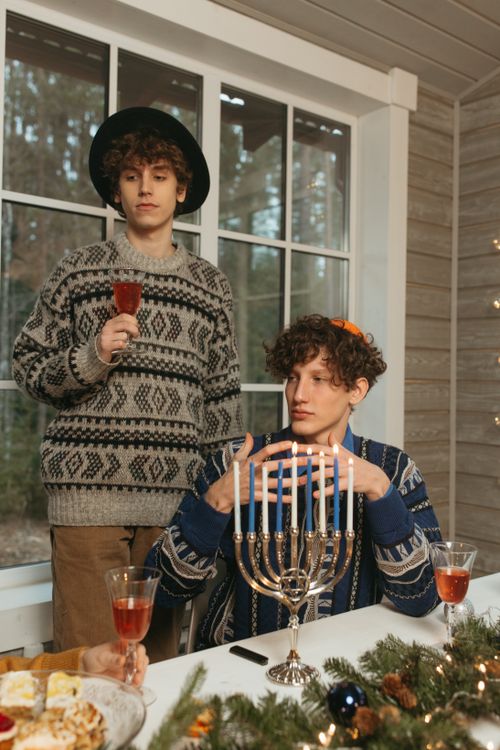 Free Two men celebrating the holidays indoors with candles and wine, featuring a menorah. Stock Photo