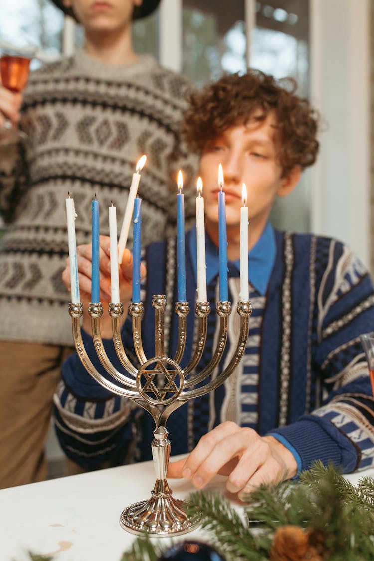 Man Lighting Candles On A Menorah