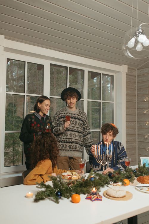Free A group enjoys a Hanukkah dinner with festive decorations indoors. Stock Photo
