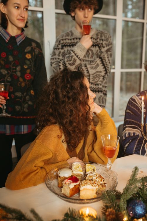 Free A cozy Hanukkah celebration with friends enjoying holiday treats and drinks indoors. Stock Photo
