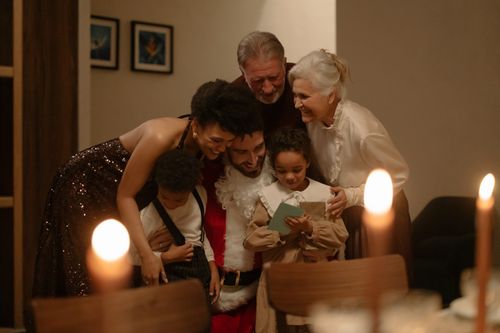 Free A joyful family gathers around Santa for a warm Christmas Eve celebration, sharing love and happiness. Stock Photo