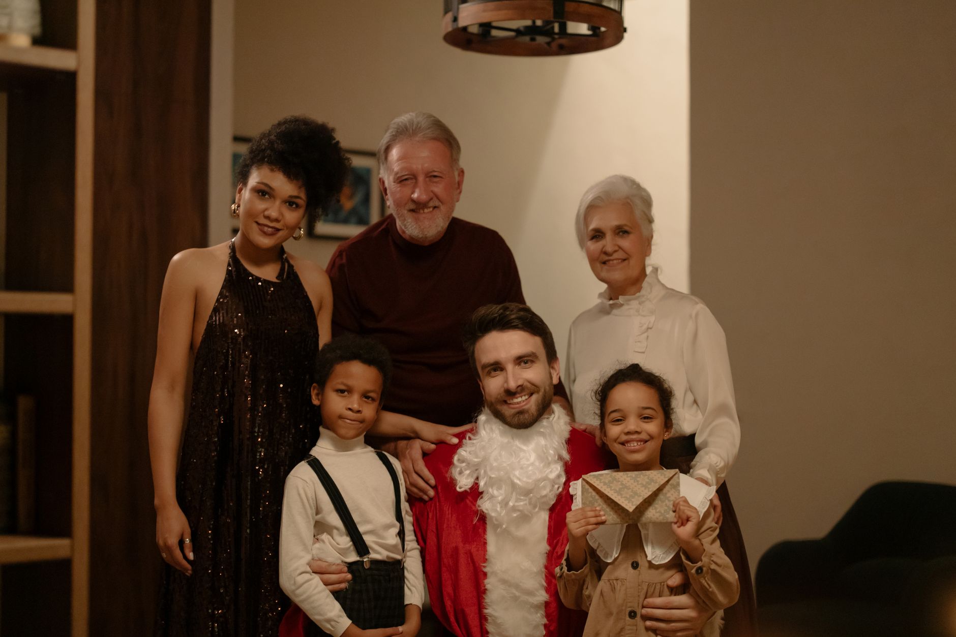 Happy family celebrating Christmas with gifts, Santa, and smiles indoors.