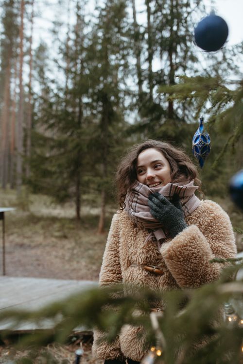 Free Woman in a fur coat enjoying the winter outdoors with Christmas ornaments. Stock Photo