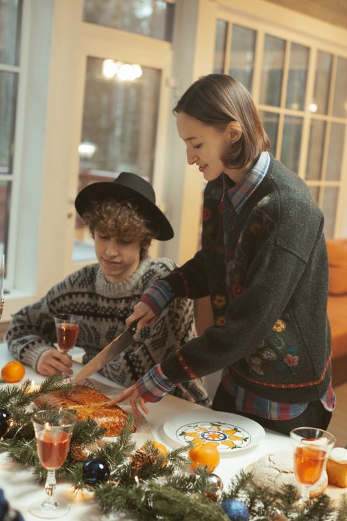 Free A warm holiday scene featuring two friends enjoying a festive Christmas dinner together indoors. Stock Photo