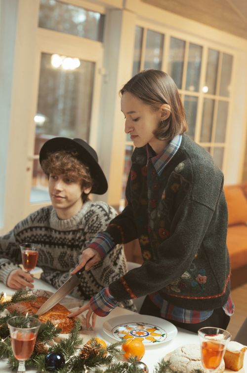 Free A cozy indoor holiday gathering with friends enjoying food and drink during winter festivities. Stock Photo