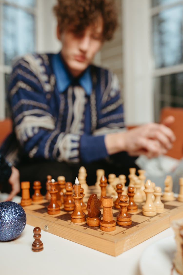 Man In Blue Sweater Playing Chess