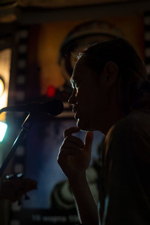 Free Dark silhouette of a man singing into a microphone, creating an artistic mood. Stock Photo