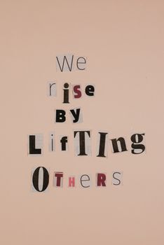 Motivational words on cutouts forming an uplifting message on a beige background.