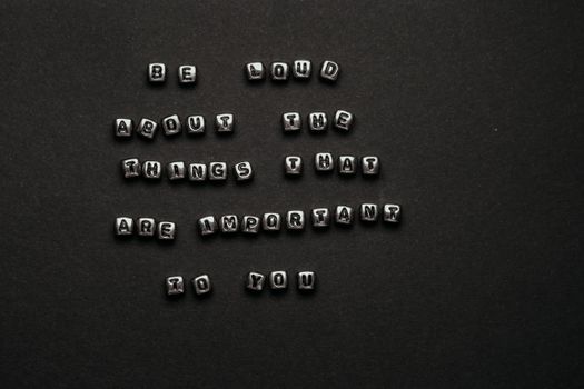 Monochrome alphabet cubes form an inspiring quote on a dark background, ideal for motivation and typography projects.