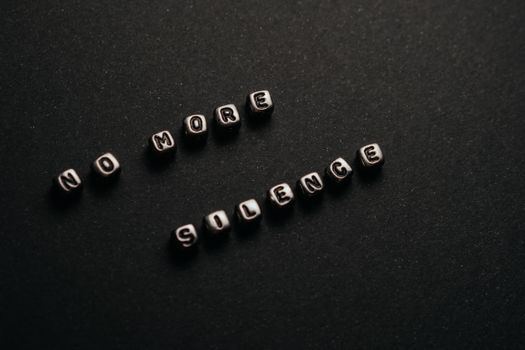 Minimalist black and white text art with message 'No More Silence' on a dark background.