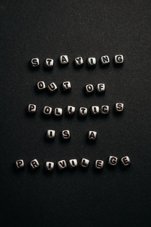 Free Monochrome close-up of a political quote using metal cube letters on a dark background. Stock Photo