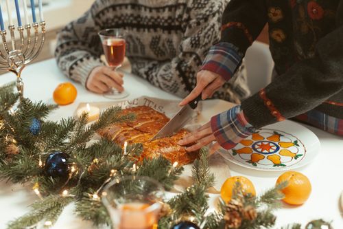 Free Festive Hanukkah table setup with traditional food, menorah, and holiday decor, capturing a warm holiday vibe. Stock Photo