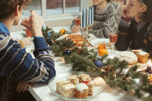 Free Cozy Hanukkah gathering with traditional food and festive décor creating a warm atmosphere. Stock Photo