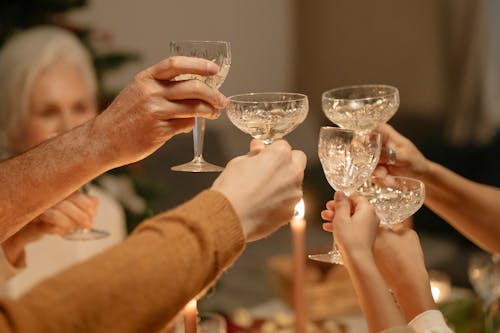 Person Holding Clear Wine Glasses