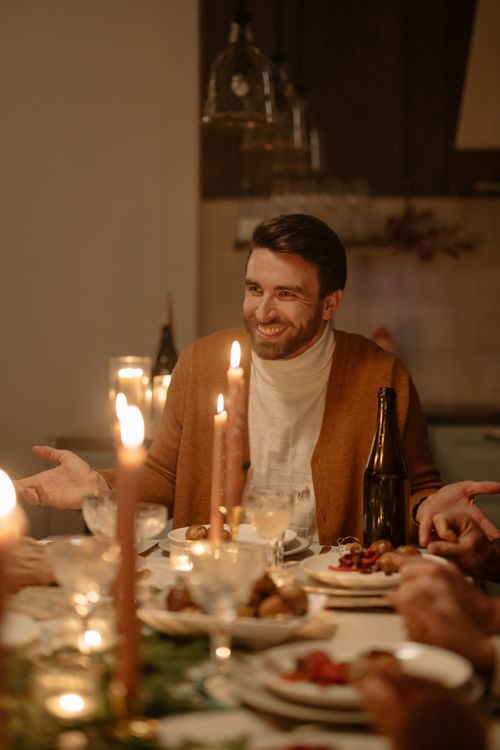 Free A joyful man enjoying a cozy candlelit family dinner gathering. Stock Photo