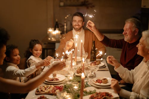 People Sitting at the Dining Table Holding Sparklers