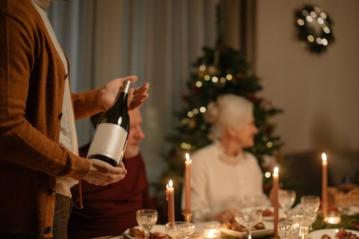 Cozy family gathering around a dinner table during the Christmas season with wine and festive decorations.