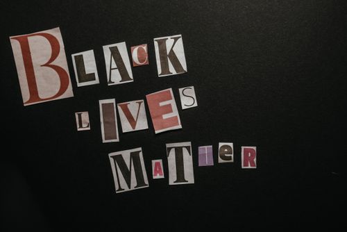 Free Cut-out letters spell 'Black Lives Matter' on a black background, representing equality and activism. Stock Photo