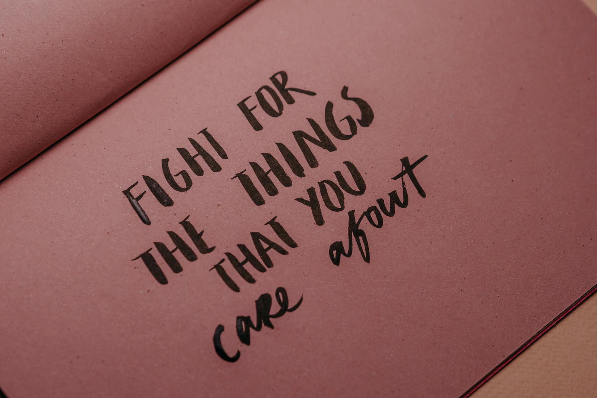 Hand-lettered inspirational quote on pink paper emphasizing motivation and self-care.