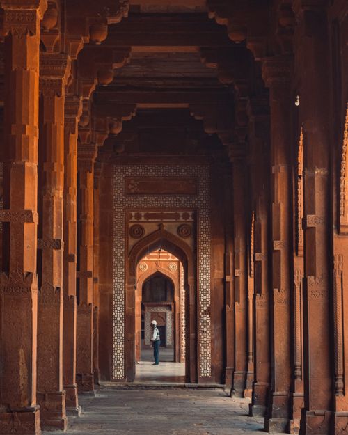 Free Explore the magnificent Mughal architecture of Fatehpur Sikri's iconic corridor captured in warm tones. Stock Photo