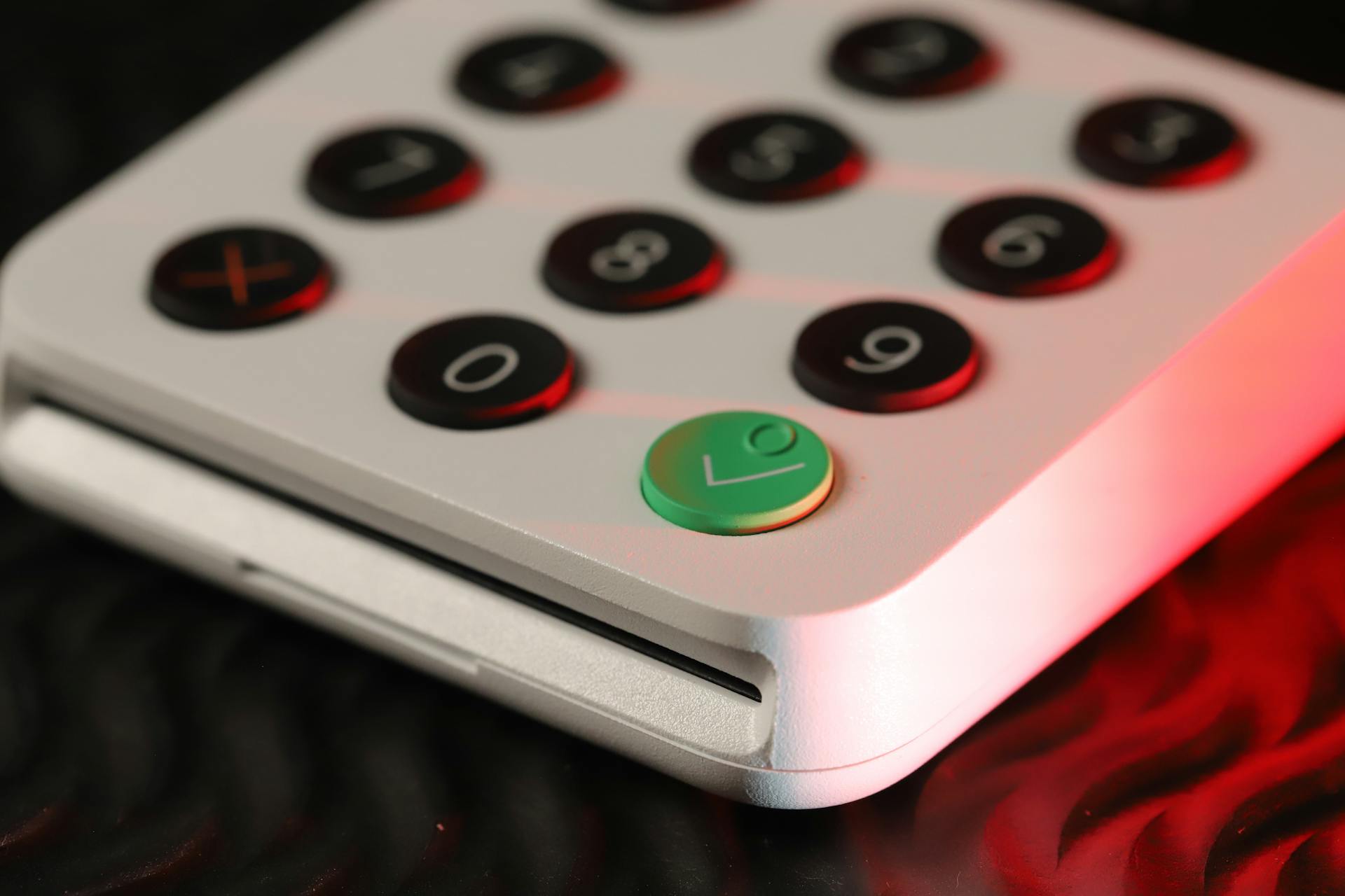 Close-up shot of a digital card reader featuring black and green buttons with numeric keypad.