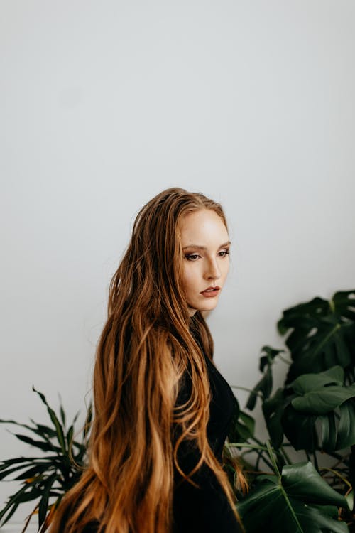 A Woman in a Black Top Standing Beside Plants