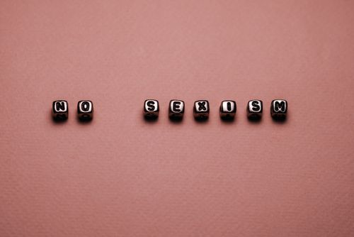 Free Cubes spelling 'No Sexism' on a brown background symbolizing gender equality. Stock Photo