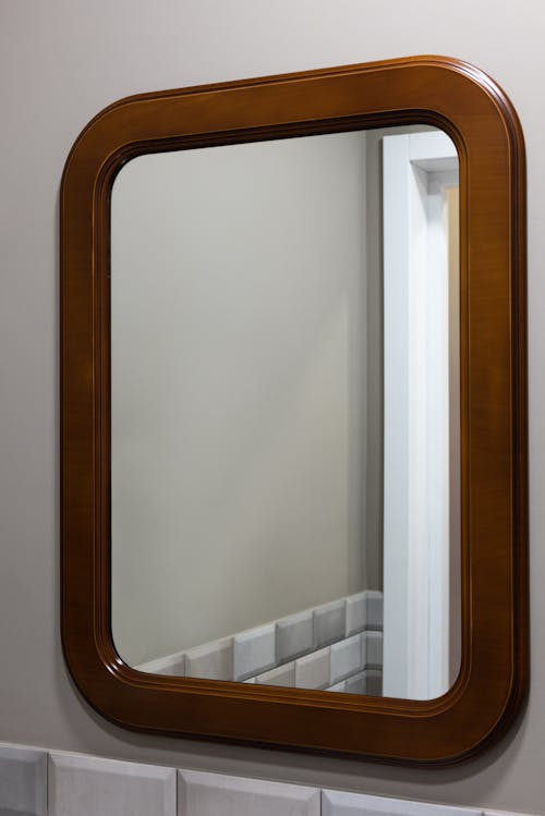 Interior of modern light bathroom with mirror placed on gray wall near door
