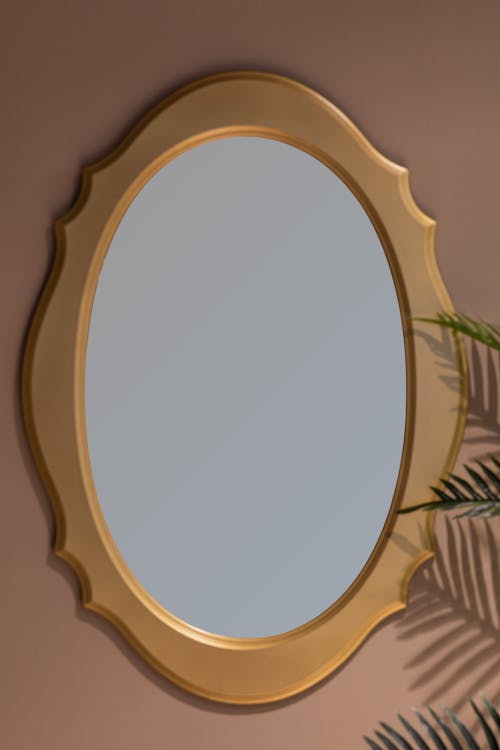 Овальное коричневое зеркало в деревянной раме