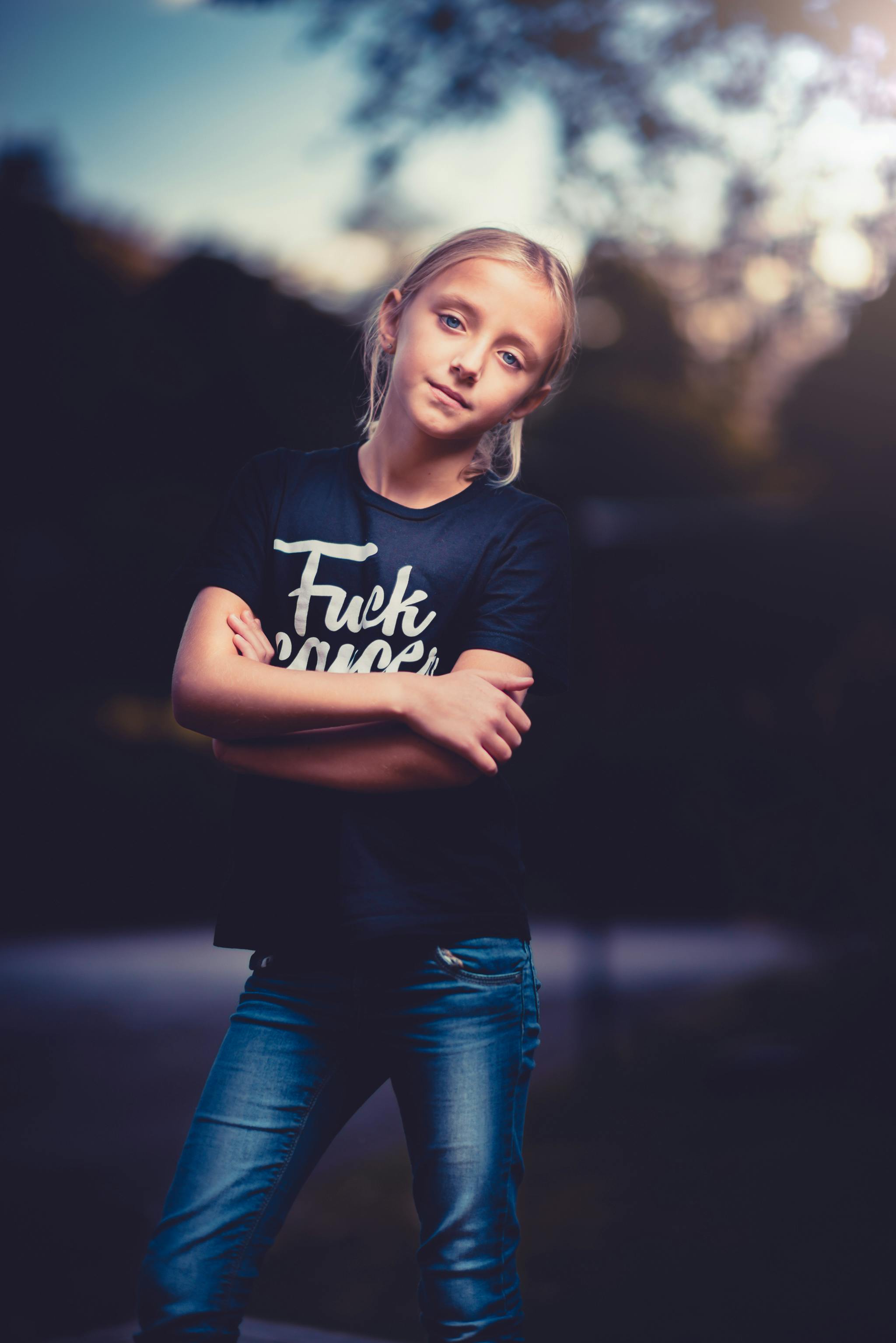 黄昏时分，一位身着休闲装的年轻女孩在户外自信地摆着姿势