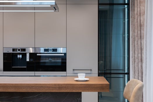 Modern room with kitchenware and counter with coffee cup near chairs and curtains with cabinet and oven