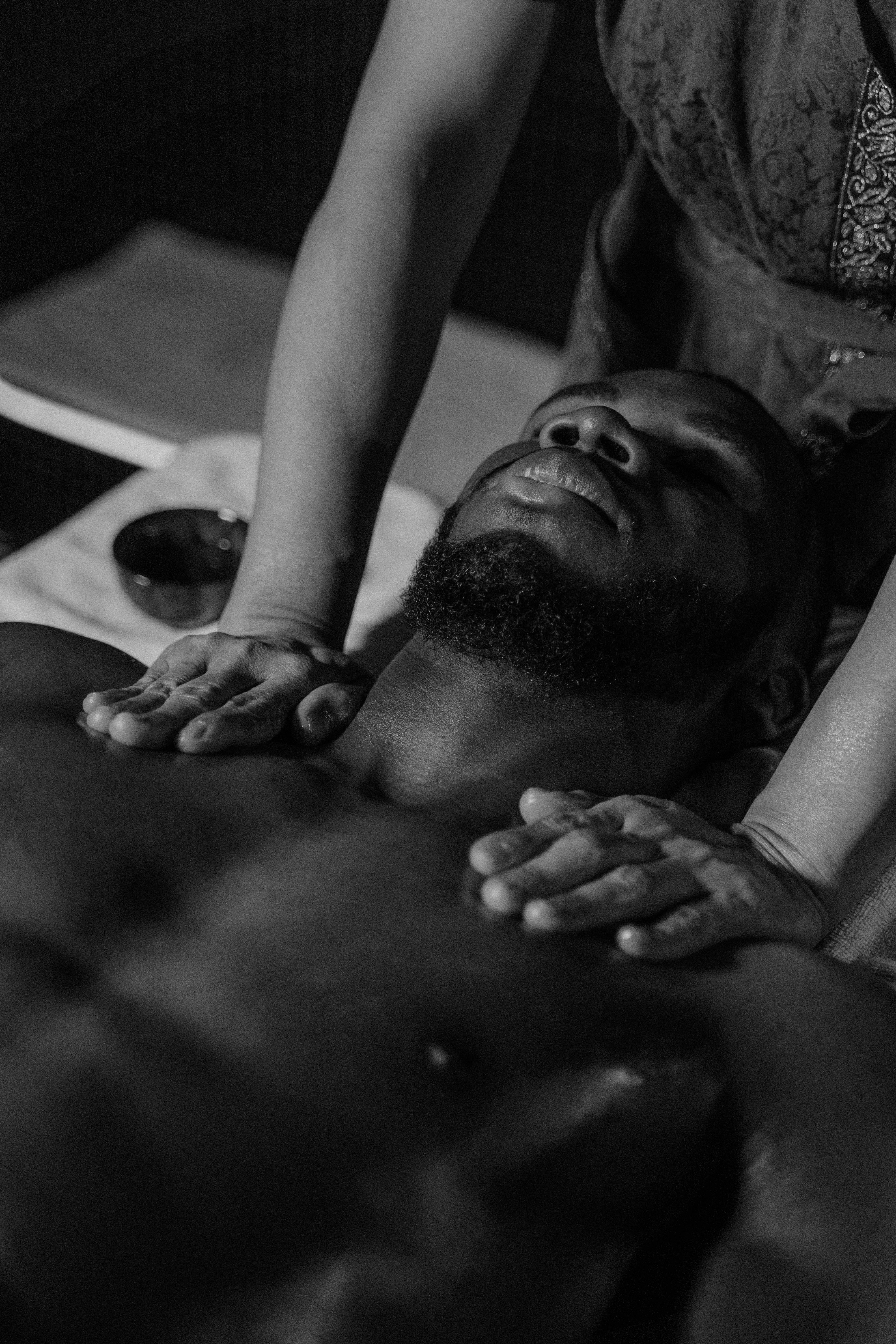 hands massaging male body lying on massage table