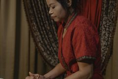 A calming spa treatment featuring a masseuse providing a soothing facial massage indoors.