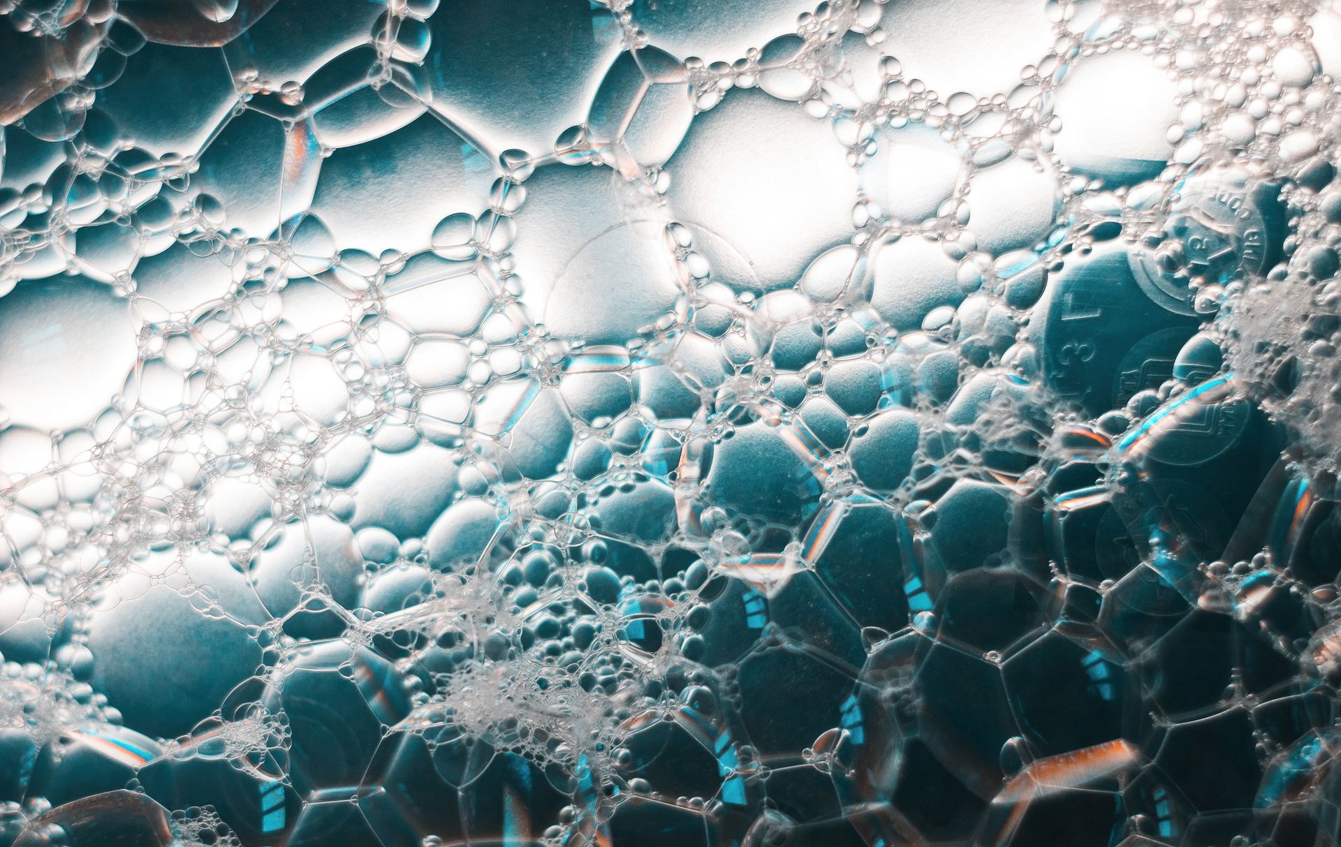 Captivating macro photo of soap bubbles with ethereal lighting and intricate patterns.