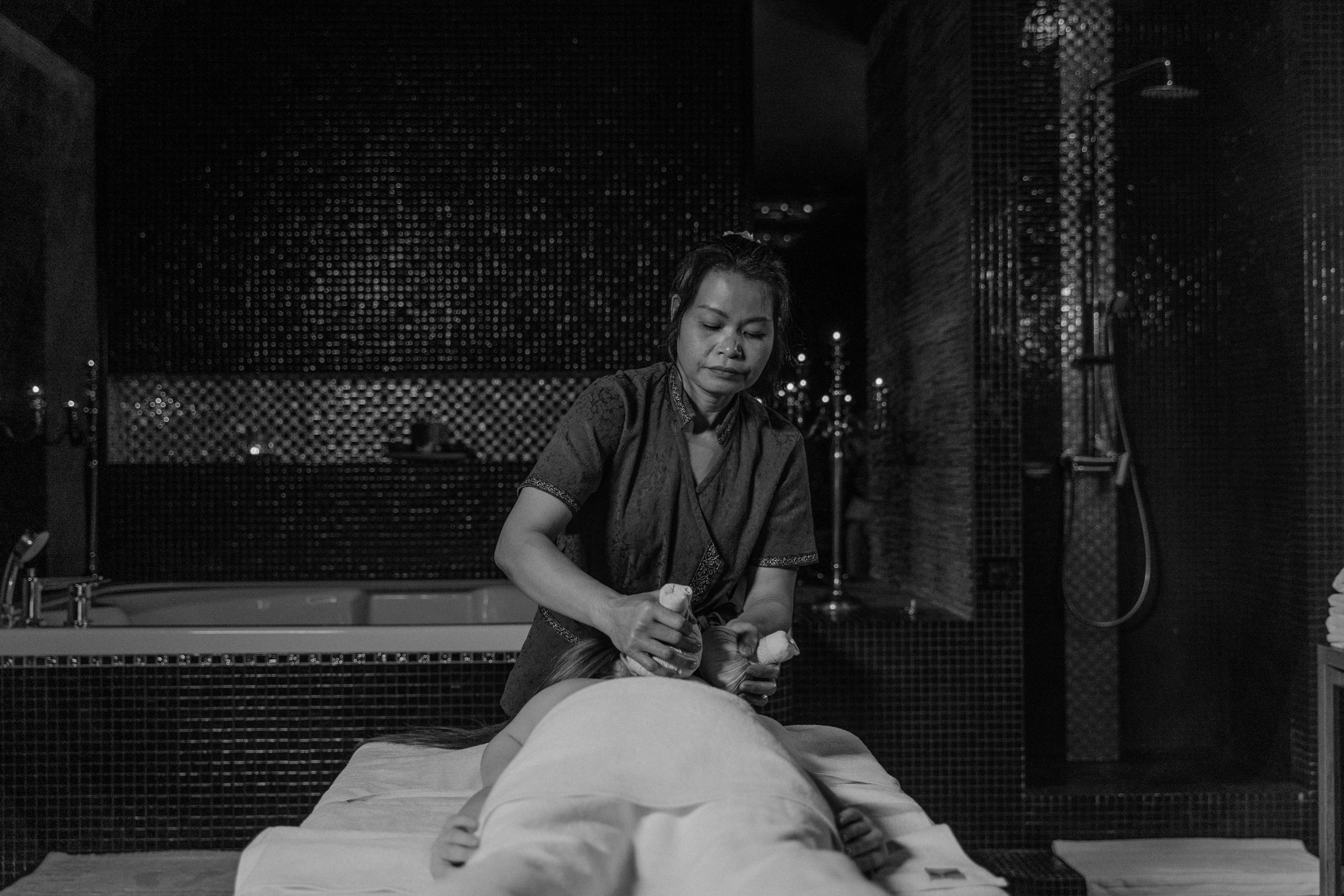 woman massaging a person on a massage table