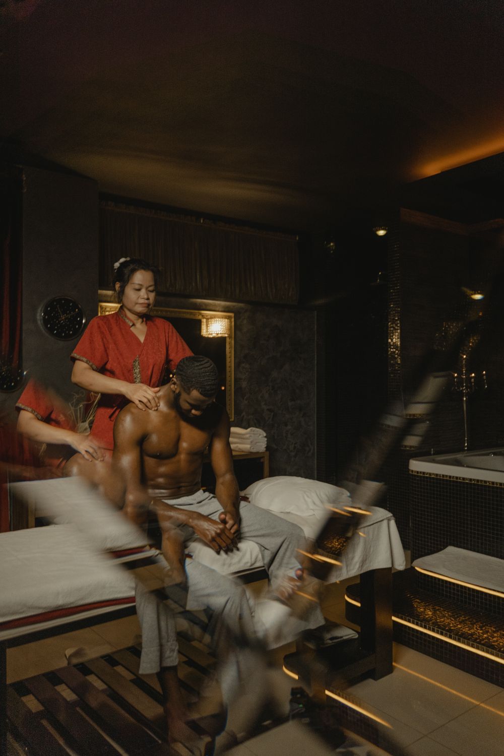 Massage therapist providing a hot stone treatment with warm stones