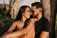 Man and Woman Kissing Near Brown Tree