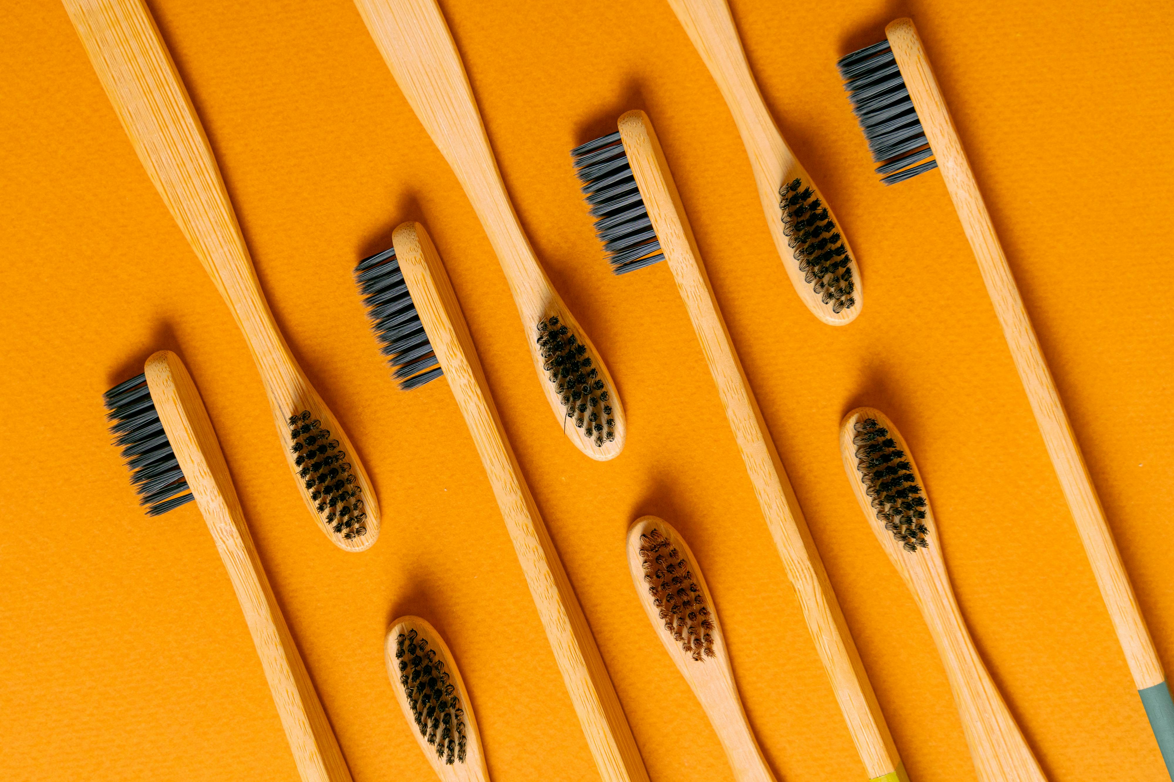 CloseUp Shot of Wooden Toothbrushes on an Orange Surface · Free Stock