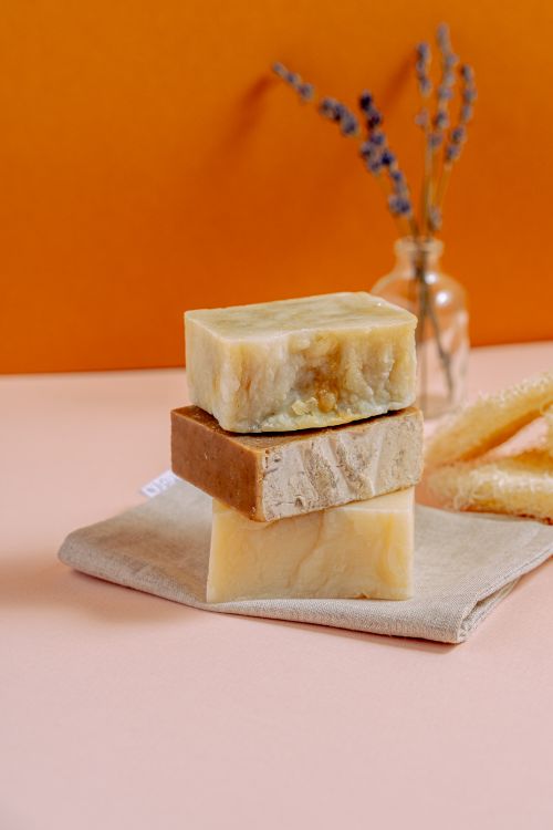 Free Three stacked natural handmade soap bars with lavender and honey on a pastel surface. Stock Photo