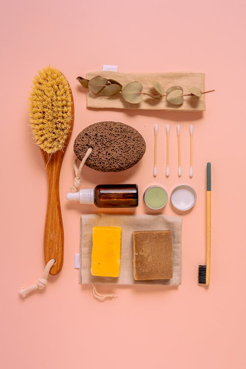 Free Flat lay of natural bath products including soaps, brush, and pumice on a peach surface. Stock Photo
