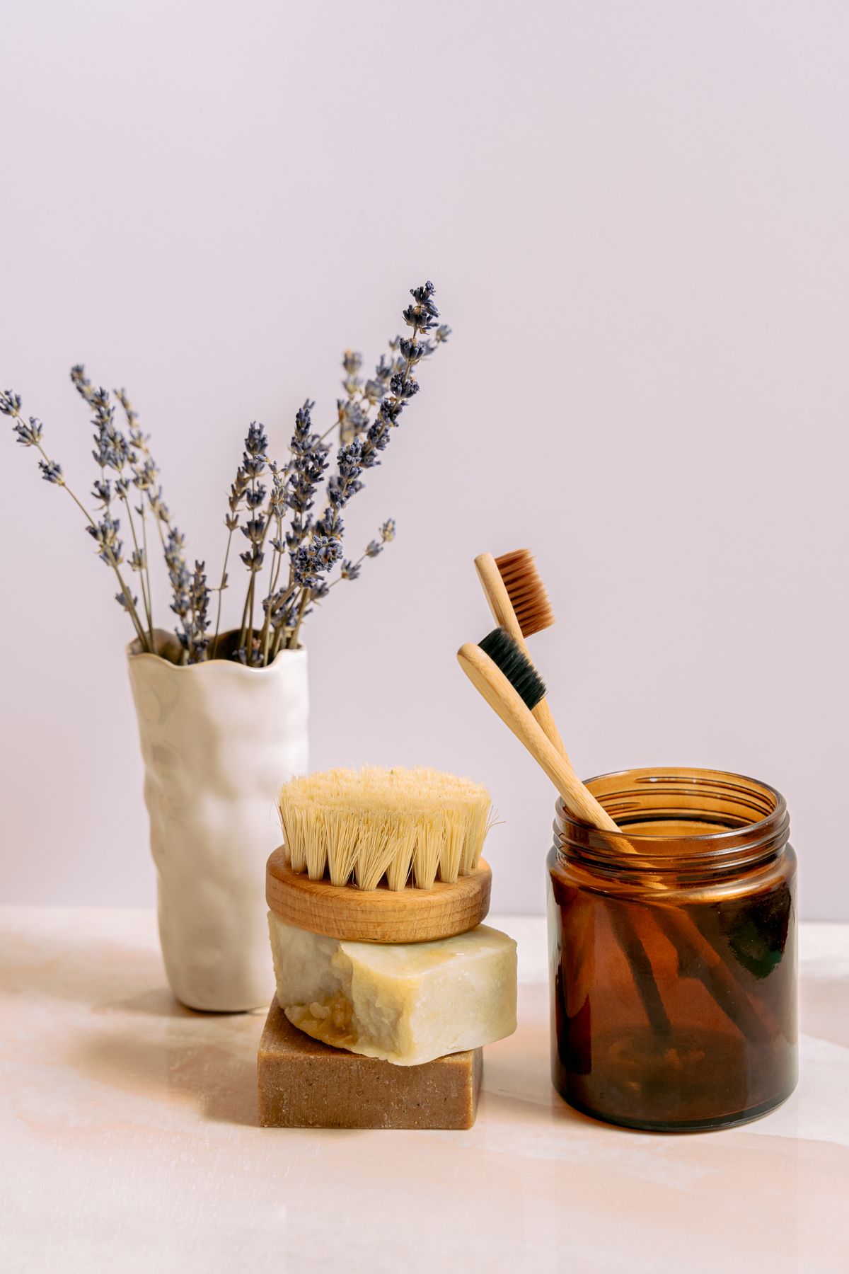 Dried lavender and an amber essential oil jar on a calm surface