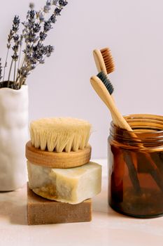 Rustic bath essentials including wooden toothbrushes, natural soaps, and a brush in a cozy setting.