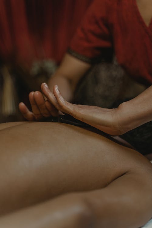 Free Hands of a Person Massaging a Person's Bare Back Stock Photo