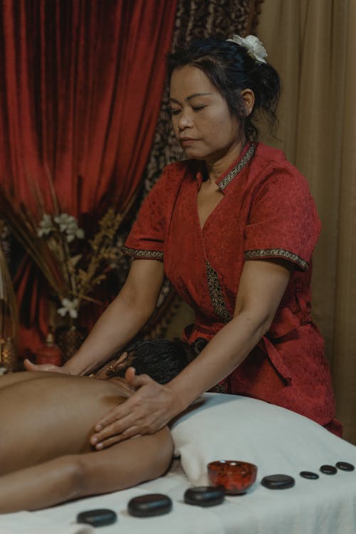 Close-Up Shot of a Woman Massaging a Person