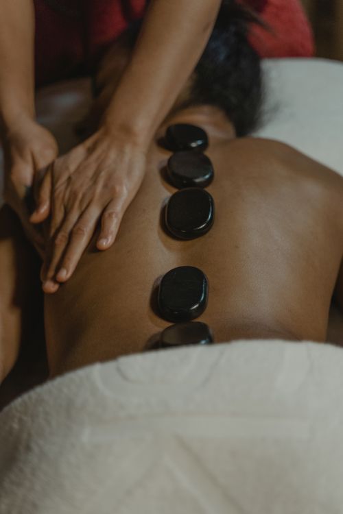 Free A soothing hot stone massage session offering relaxation and stress relief in a serene setting. Stock Photo