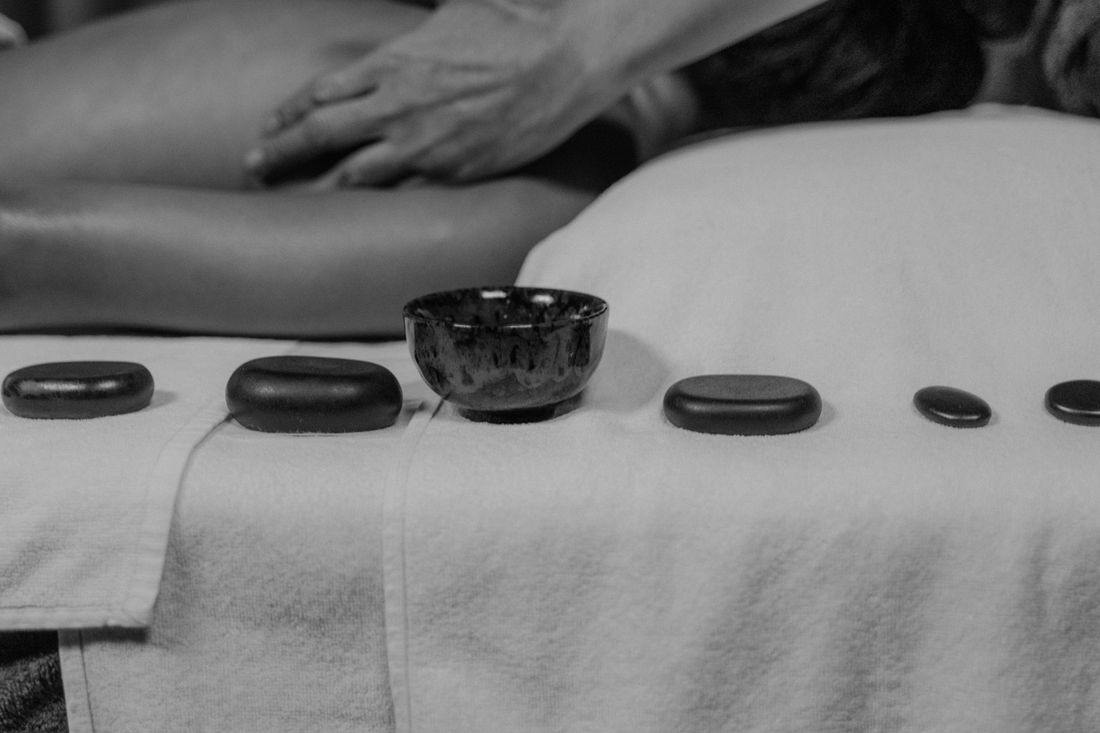 Female massage therapist giving a relaxing body massage to a male client