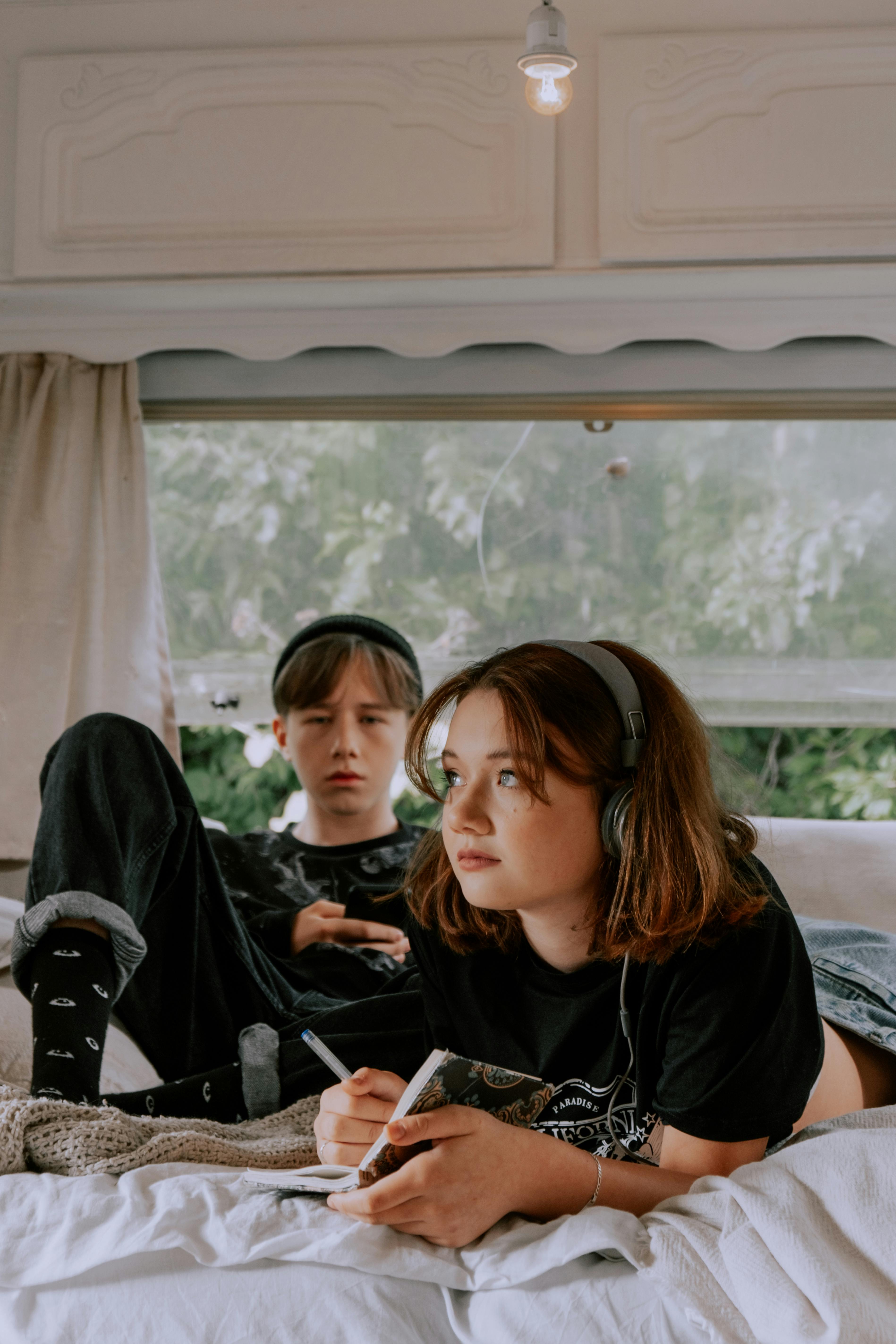 a teenager boy and girl lying on the bed