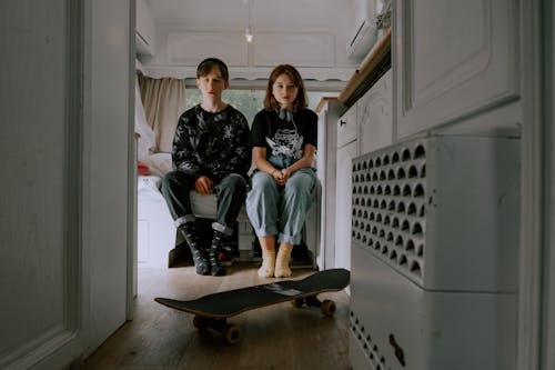 A Teenager Boy and Girl Sitting Inside a Room