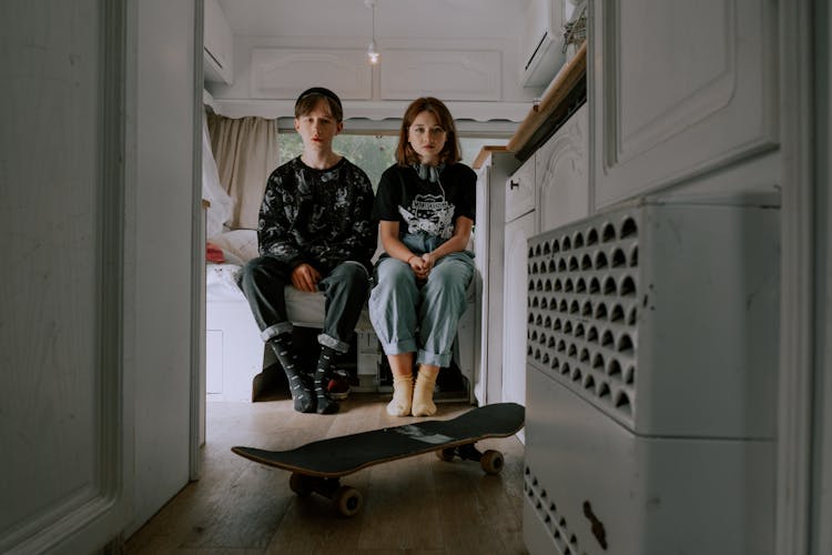 A Teenager Boy And Girl Sitting Inside A Room